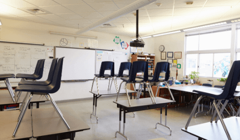 A school classroom with chairs on the tables