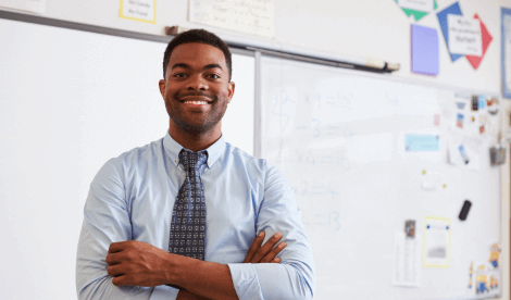 Male teacher in classroom looking to camera