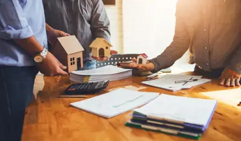 3 people discussing real estate and funding around a table